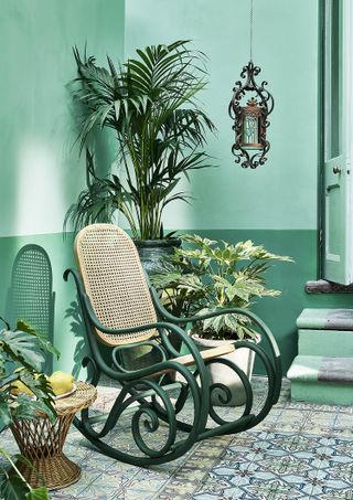 colourful garden furniture ideas: green rocking chair on courtyard painted with annie sloan green