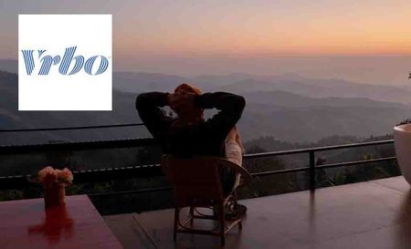 vrbo logo top left with man relaxing on balcony