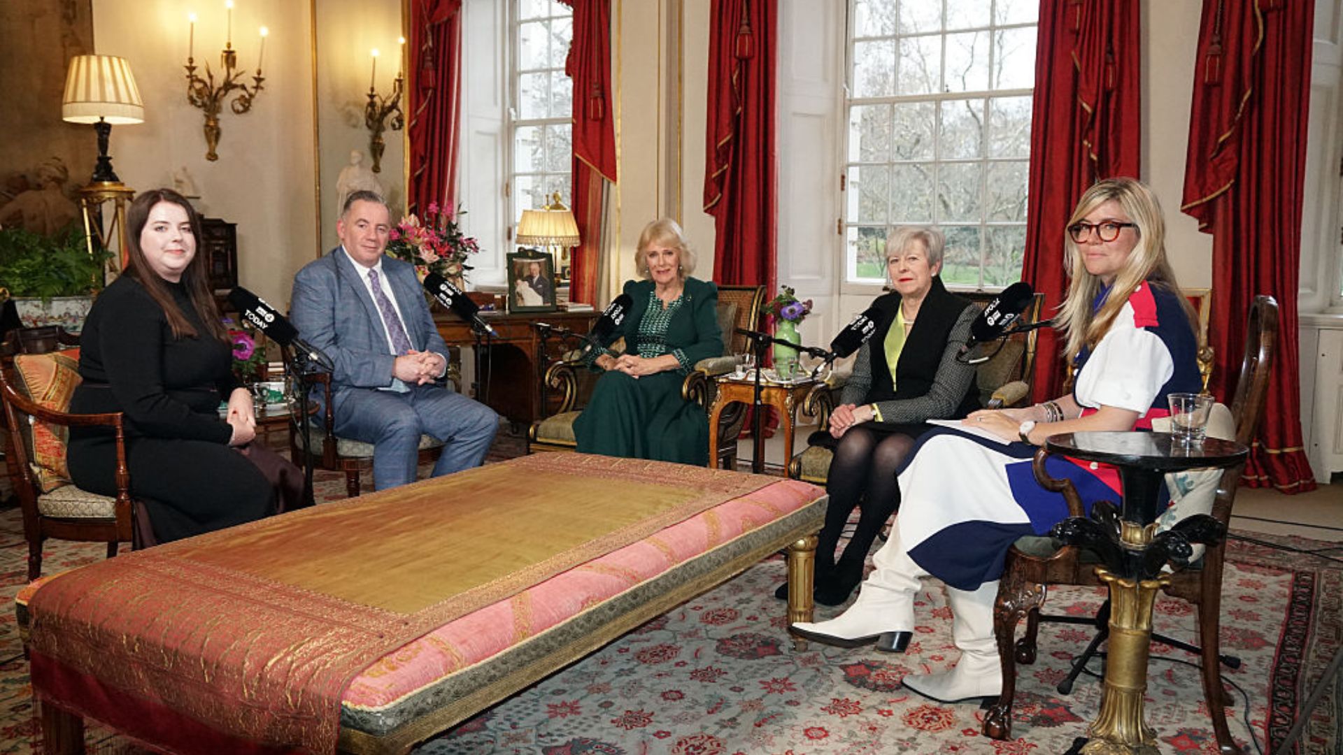 Queen Camilla (C) with (left to right) Amy Hunt, John Hunt, former prime minister Baroness May and Emma Barnett are photographed during a meeting that forms the basis of a special radio broadcast on New Year's Eve in the Garden Room at Clarence House in London.