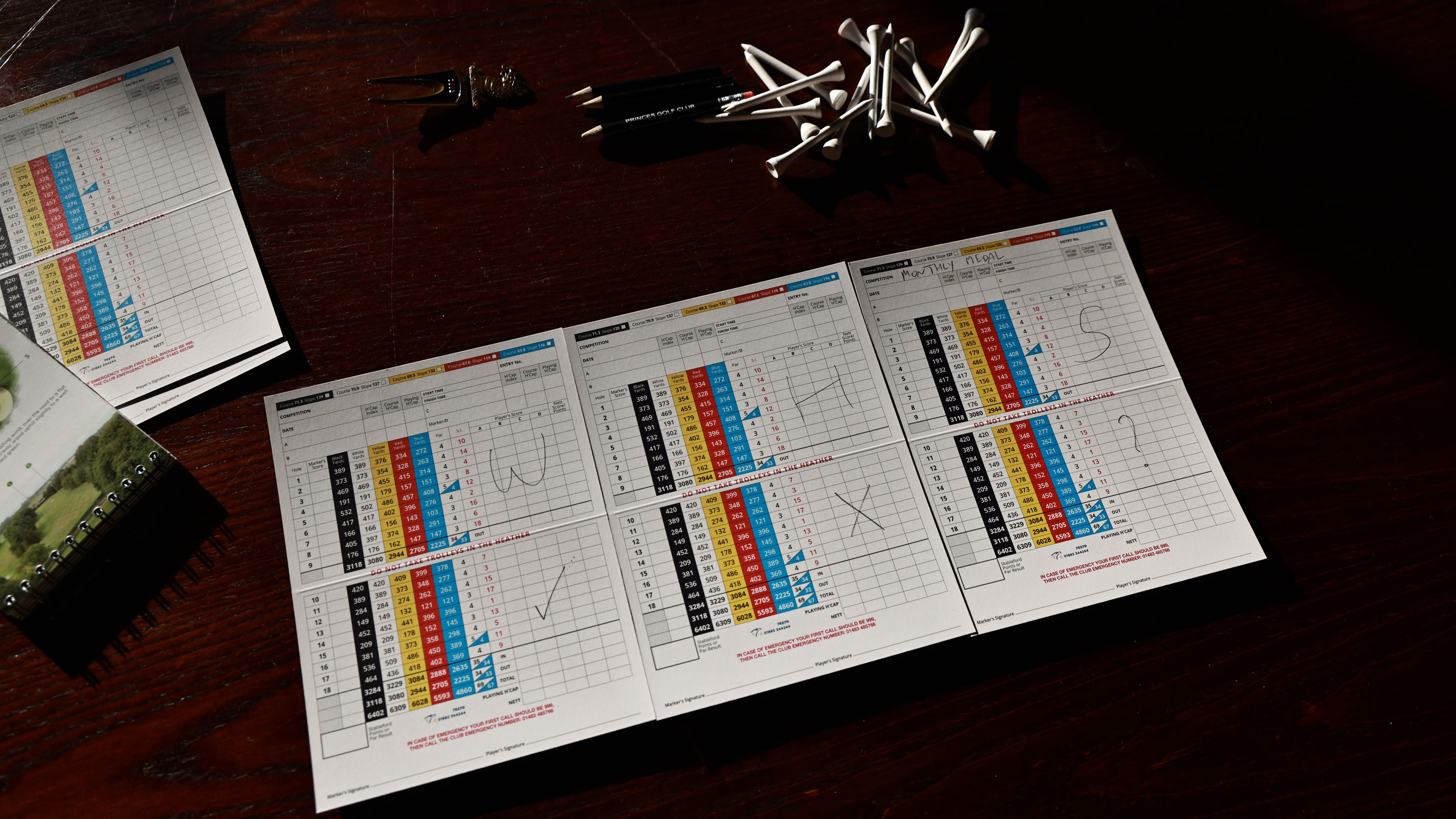 golf scorecards on a table with the letters WHS written across them