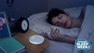 The Dodow sleep device shown on a bedside table next to a sleeping woman