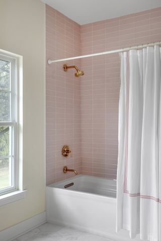 shower bathroom with pink subway tiles and copper hardware