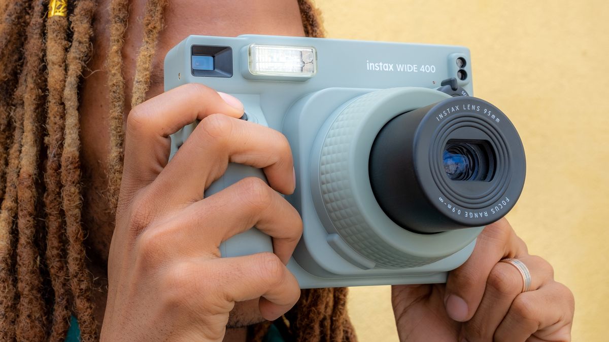 A person holding the Fujifilm Instax Wide 400 instant camera