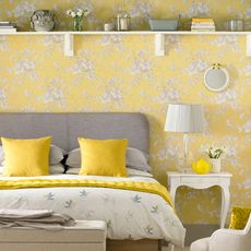bedroom with floral wallpaper and table lamp
