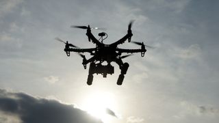 the silhouette of a drone against a sunset