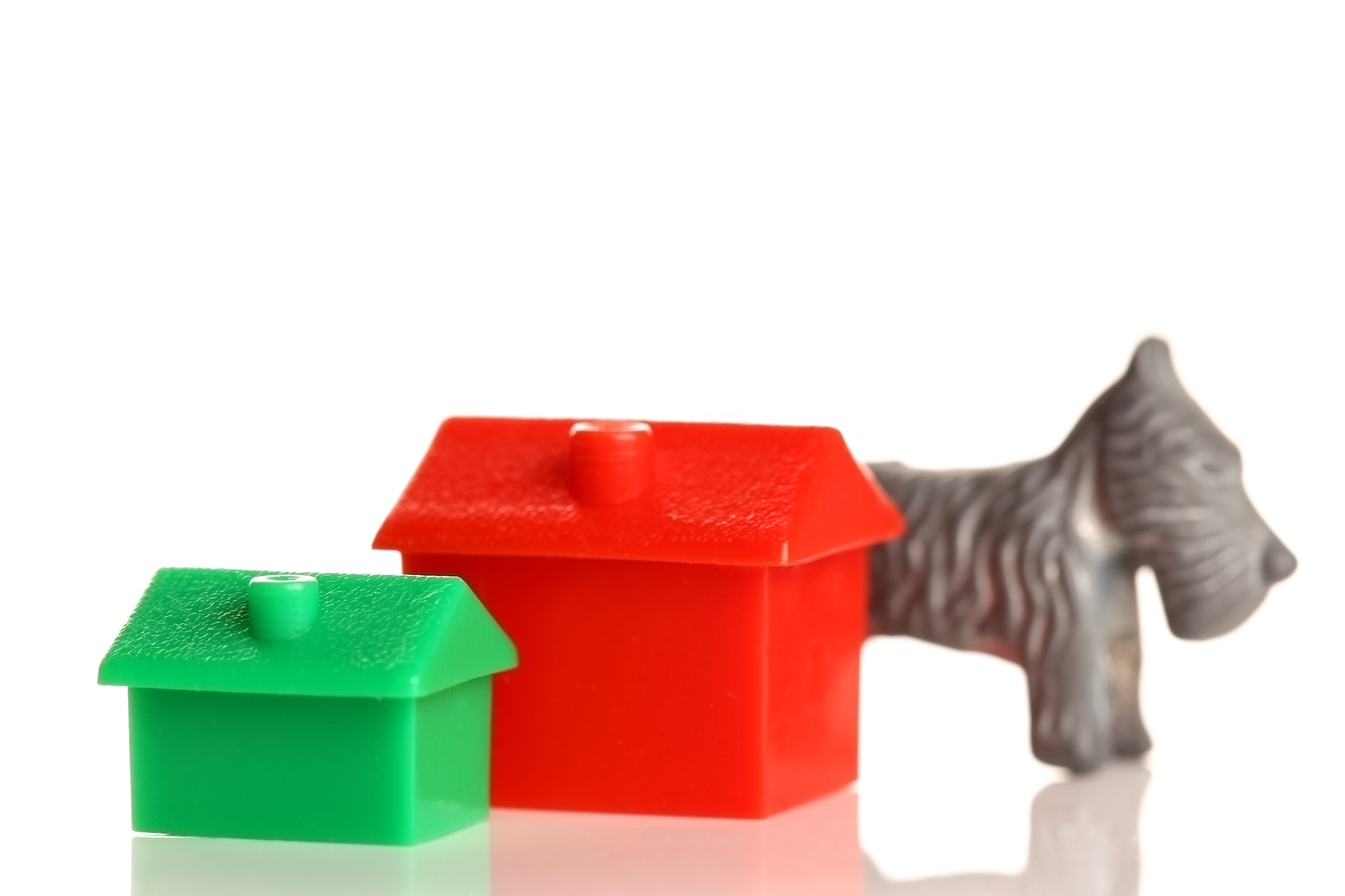 Monopoly game pieces. Monopoly is a board game named after the concept of dominating a market, a monopoly. Players take turns to move around a board and buy property.