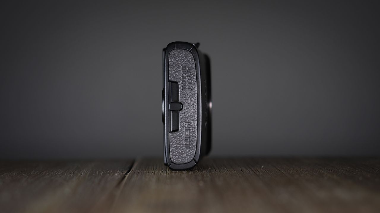 Canon Ixus 285 HS A on a wooden surface against a dark background