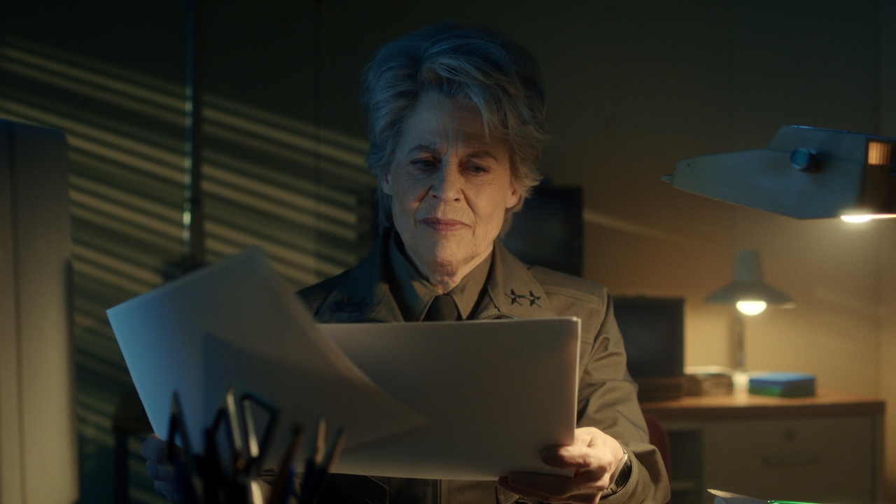 Linda Hamilton's Dr. Kay looking over papers at her desk in Stranger Things
