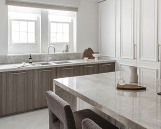 A kitchen with quartzite countertops and grey oak veneer cabinets