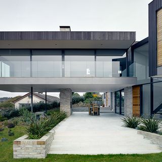 Exterior of house with glass partition and lawn