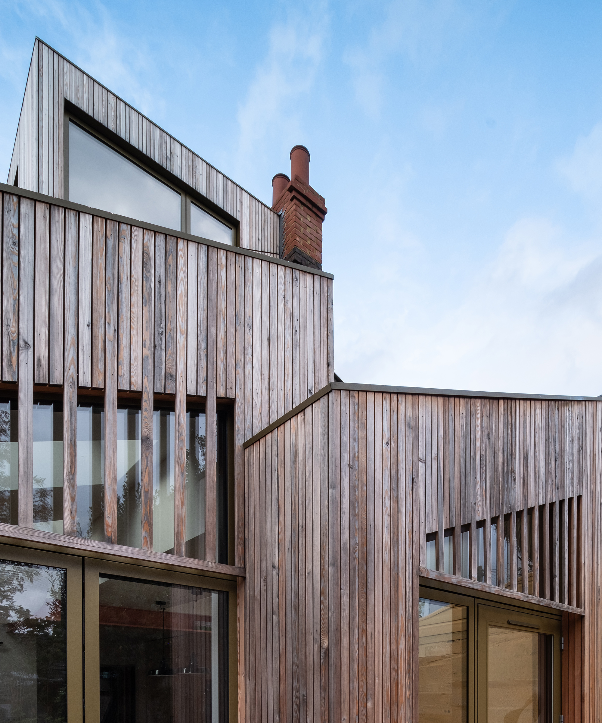 A three storey house extension with pale timber cladding