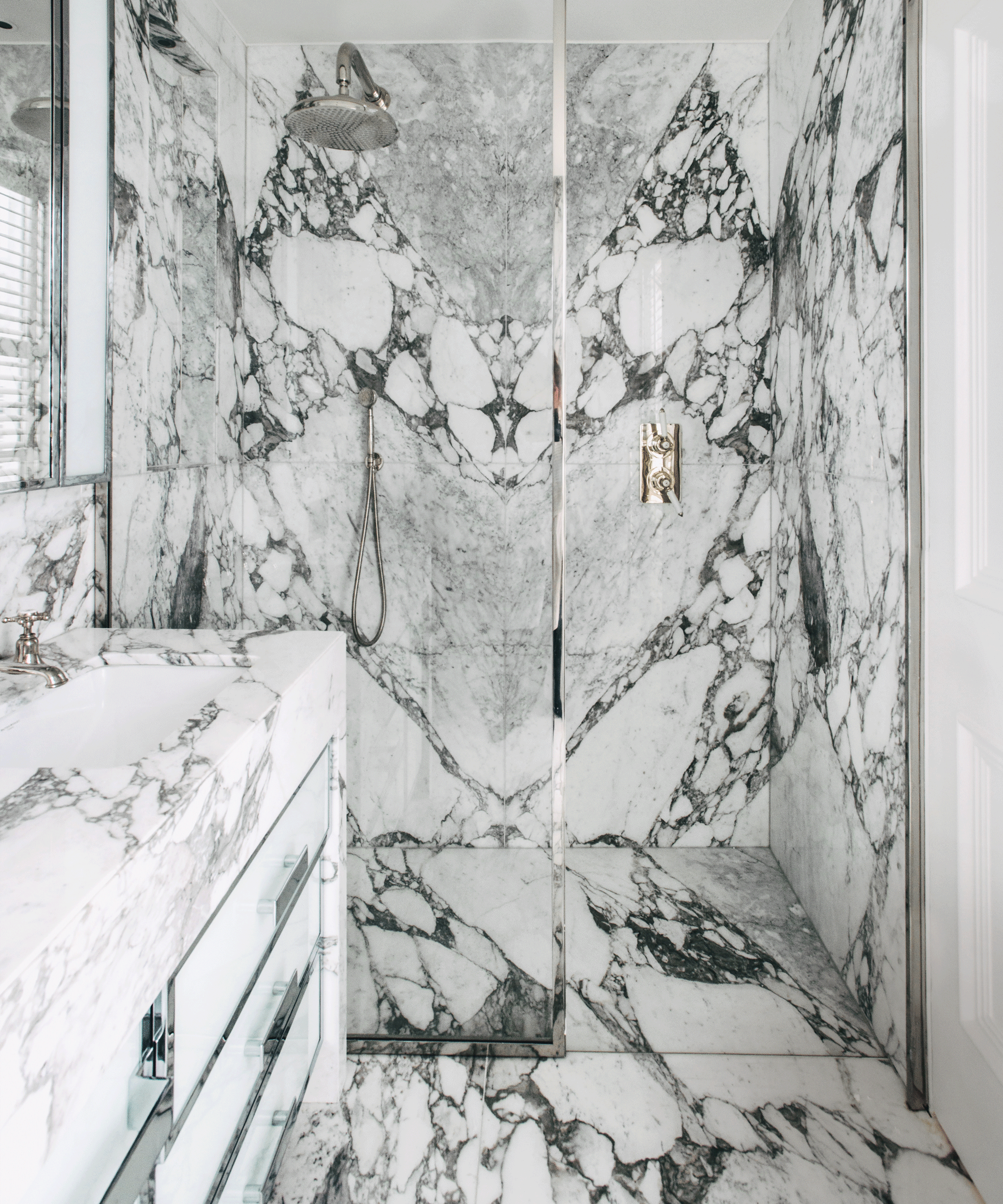 Shower with deeply veined marble floor and wall