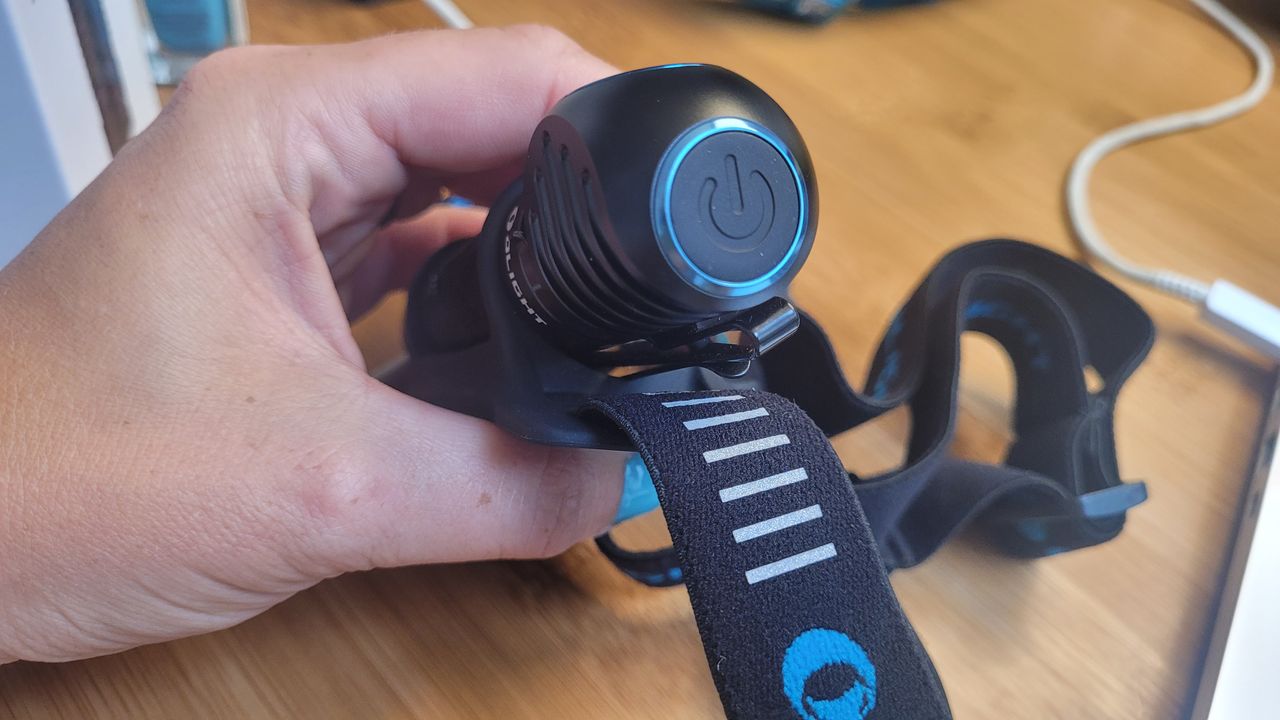 A close up of the large single button on the Olight Perun 2