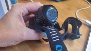 A close up of the large single button on the Olight Perun 2