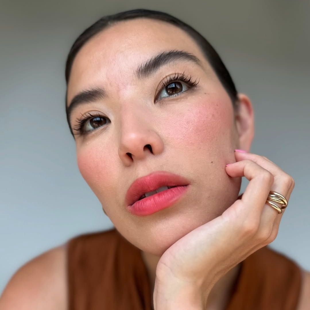 Selfie of a woman posing with her head resting in her hand.