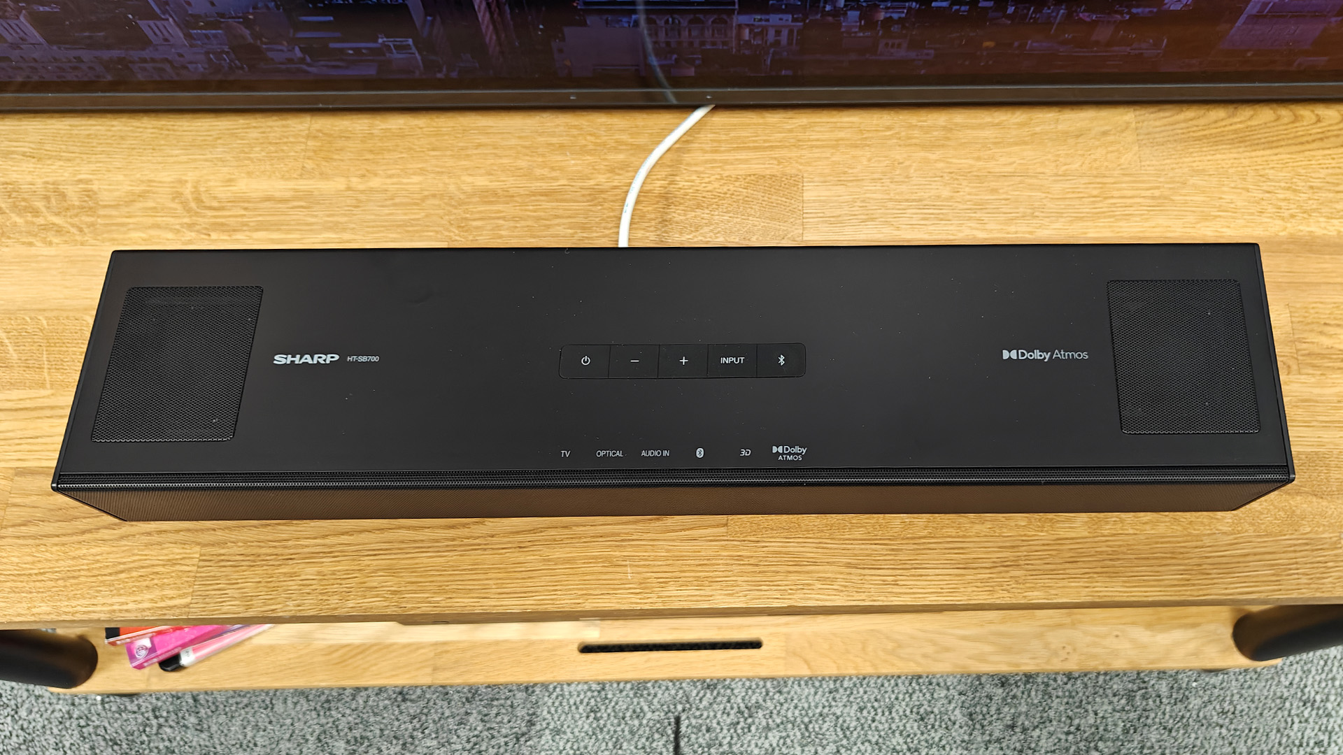 Sharp HT-SB700 Dolby Atmos soundbar on wooden AV rack viewed from above