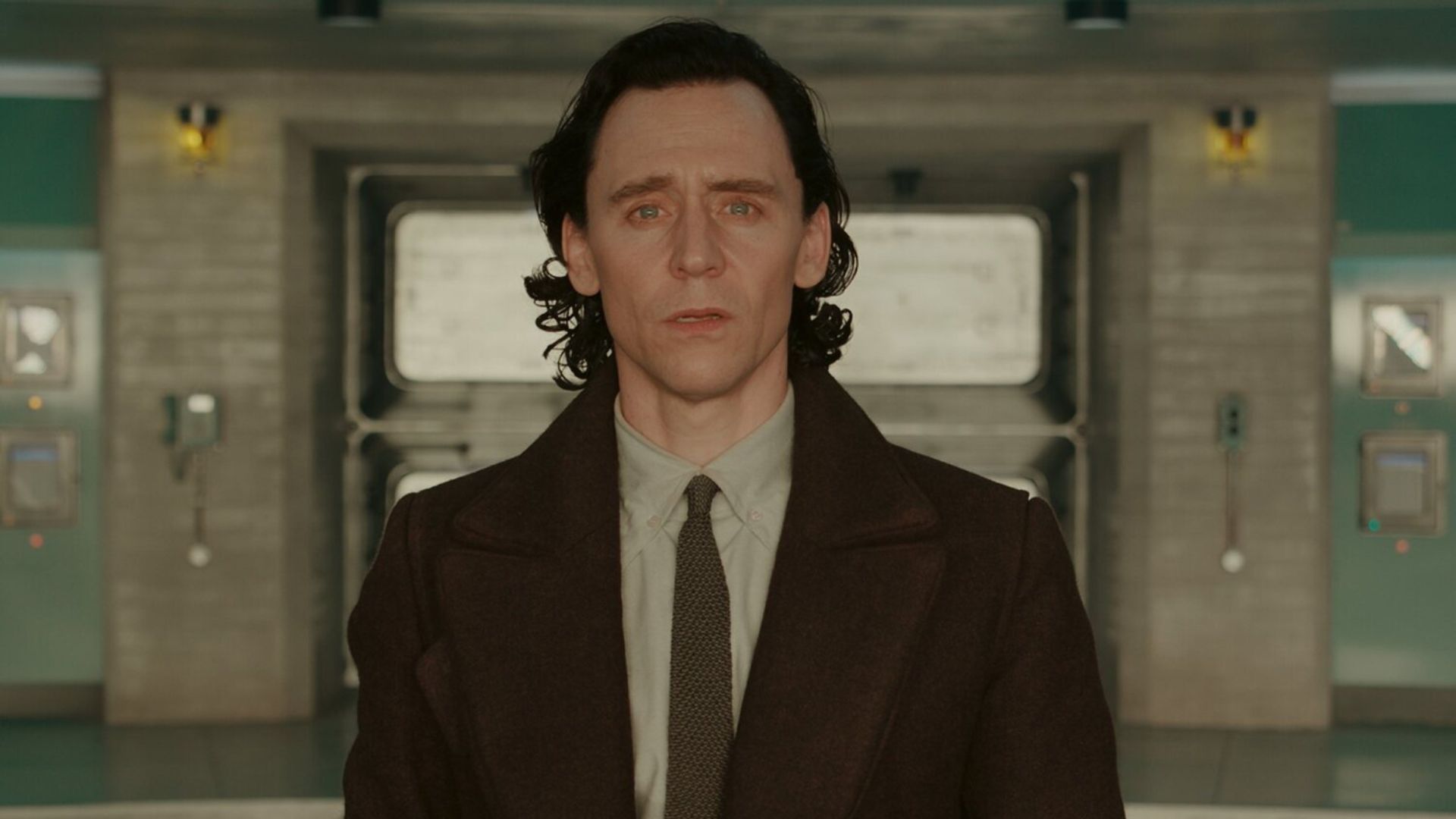Tom Hiddleston stands in a bathroom looking astonished