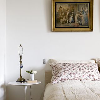 bedroom with white walls and painting on wall