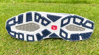 The outsole of the FootJoy Pro SL Sport on a tee box