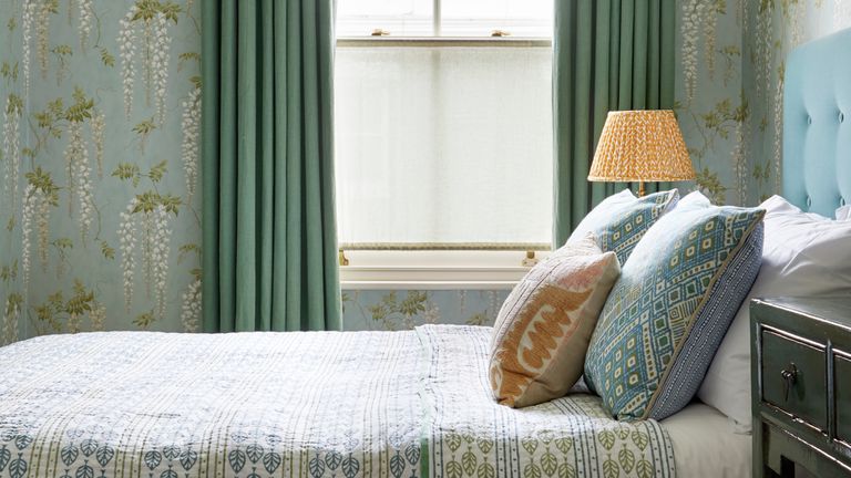 Green bedroom with wallpaper and long drapes