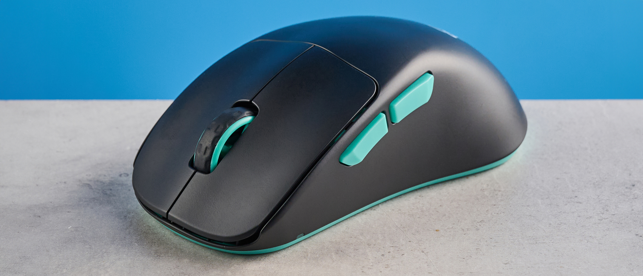 A black and teal Cherry XTRFY M64 Wireless gaming mouse