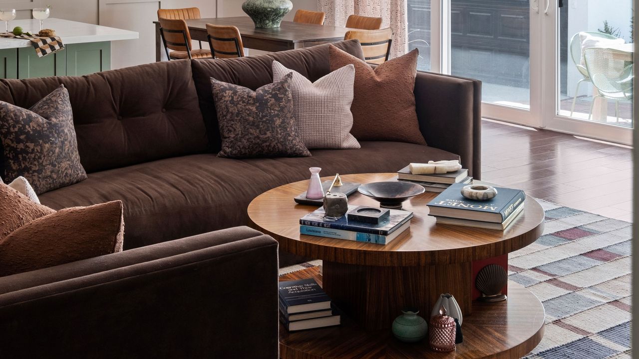 a brown sofa styled with throw pillows