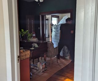 A delivery driver carrying the Stearns & Foster Estate Mattress through an entryway.