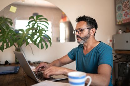 Mature man using laptop to work at home