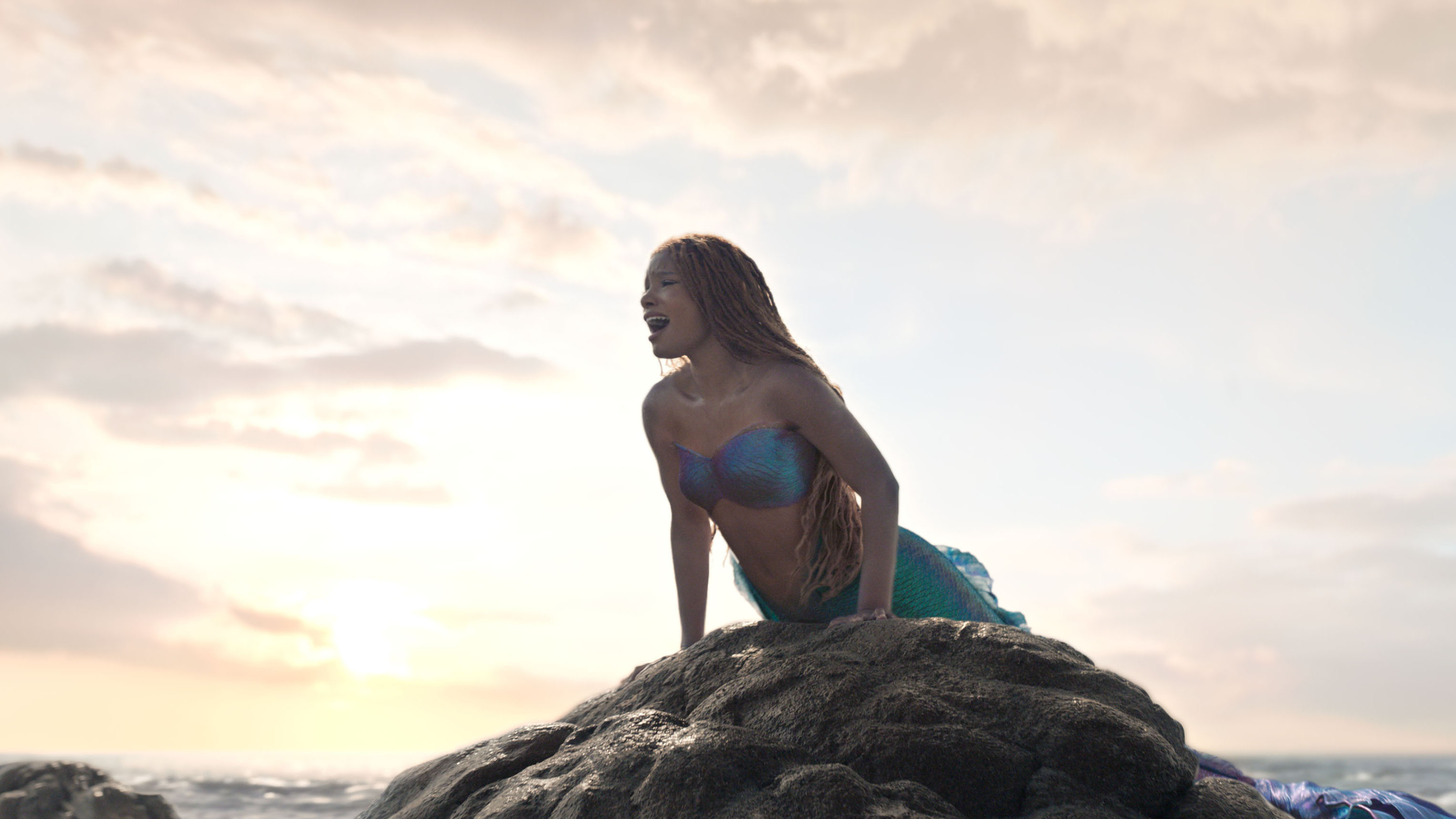 Ariel canta deitada em uma pedra em A Pequena Sereia