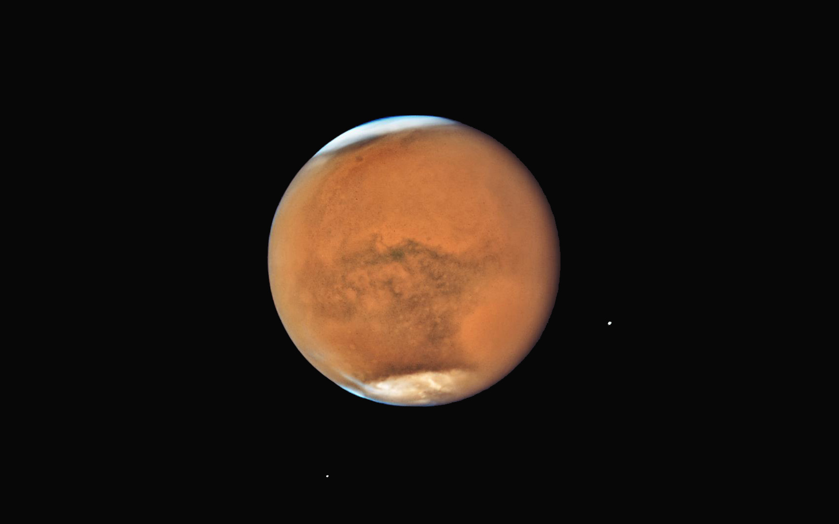 The Hubble Space Telescope captured this crystal-clear view of Mars and its two moons Phobos and Deimos in mid-July, when a massive dust storm was still raging across the planet's surface. Today, the Red Planet will reach opposition, when it is on the opposite side of Earth as the sun. Mars will make its closest approach to Earth since 2003 on Tuesday (July 31).