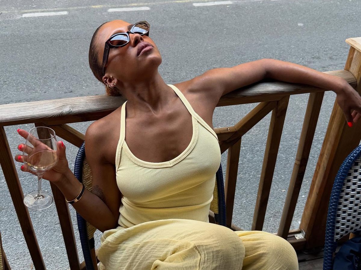 Influencer MV Tiangue wears a yellow racerback tank top and yellow linen trousers with brown sunglasses.