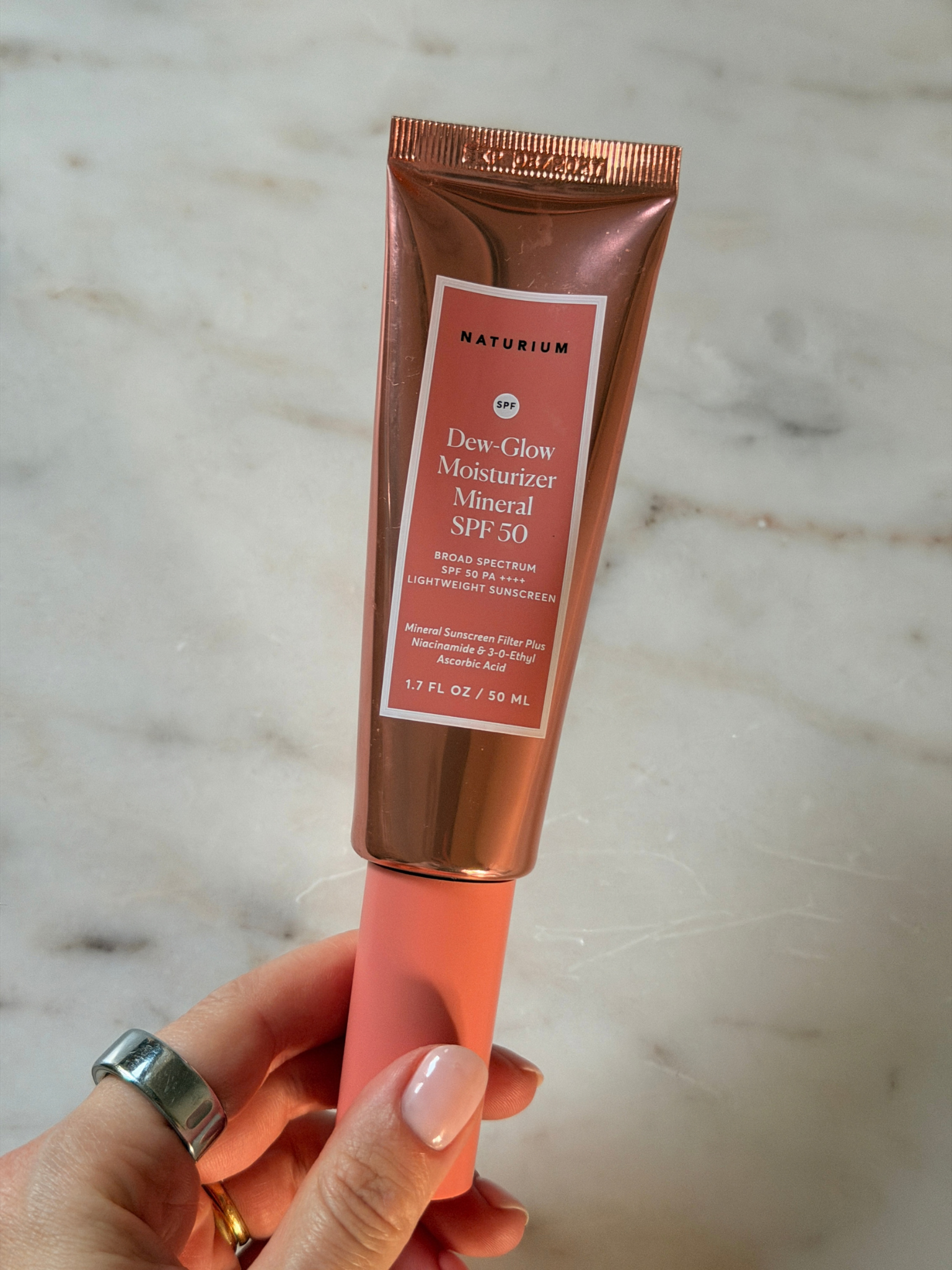 Freelance beauty editor Grace Day holding the Naturium sunscreen