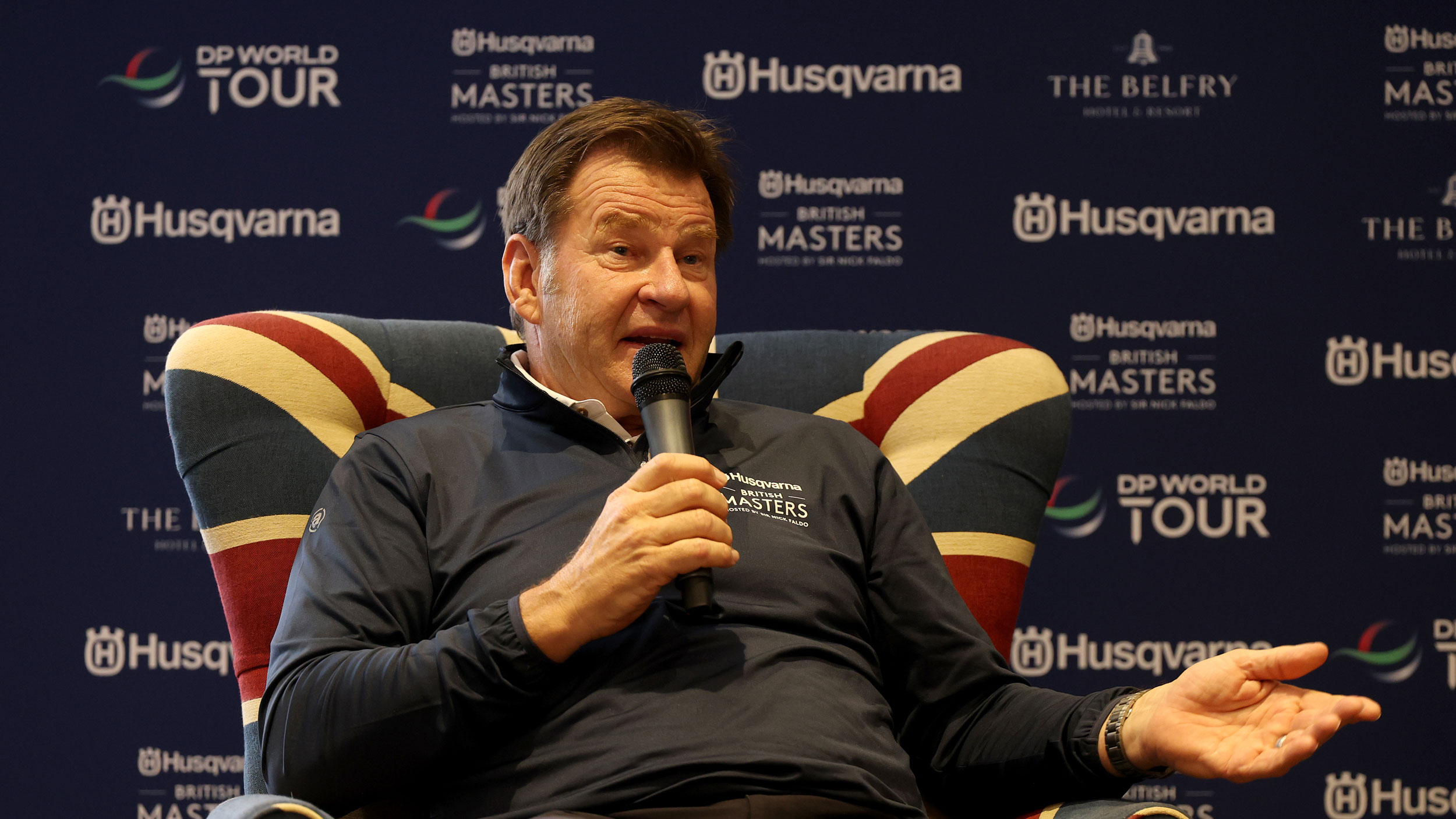 Sir Nick Faldo speaks into a microphone while sat in a Union Jack chair ahead of the 2026 British Masters