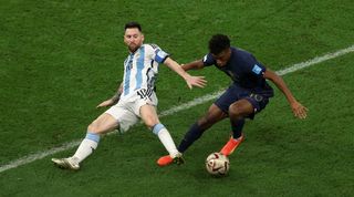 Kinglsey Coman is challenged by Lionel Messi in the World Cup 2022 final between France and Argentina.