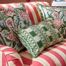 Close up of Jacquard Stripe Oblong Green cushion on a red and white striped armchair.