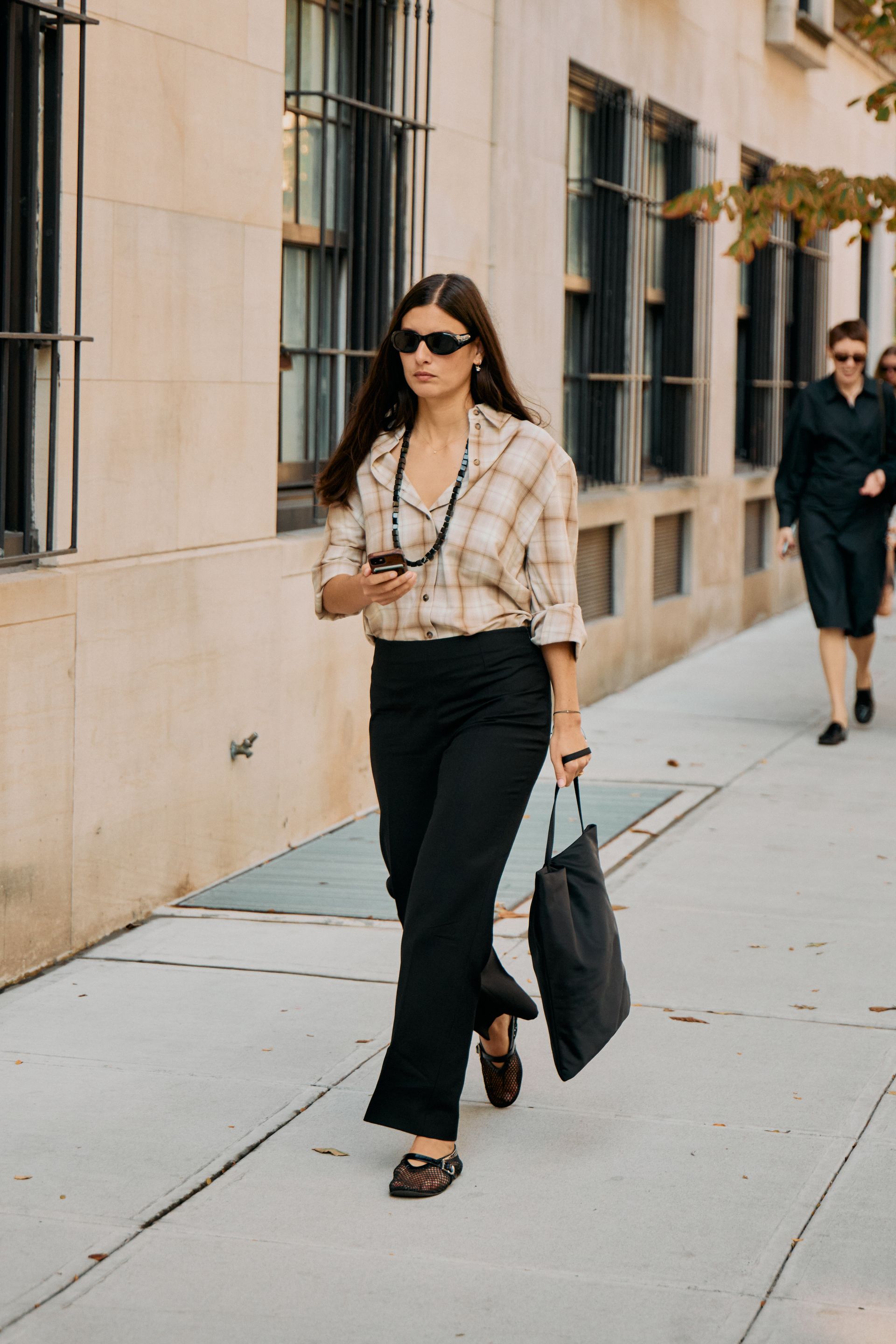 A guest wearing a plaid shirt at the COS F/W 25 show during NYFW.