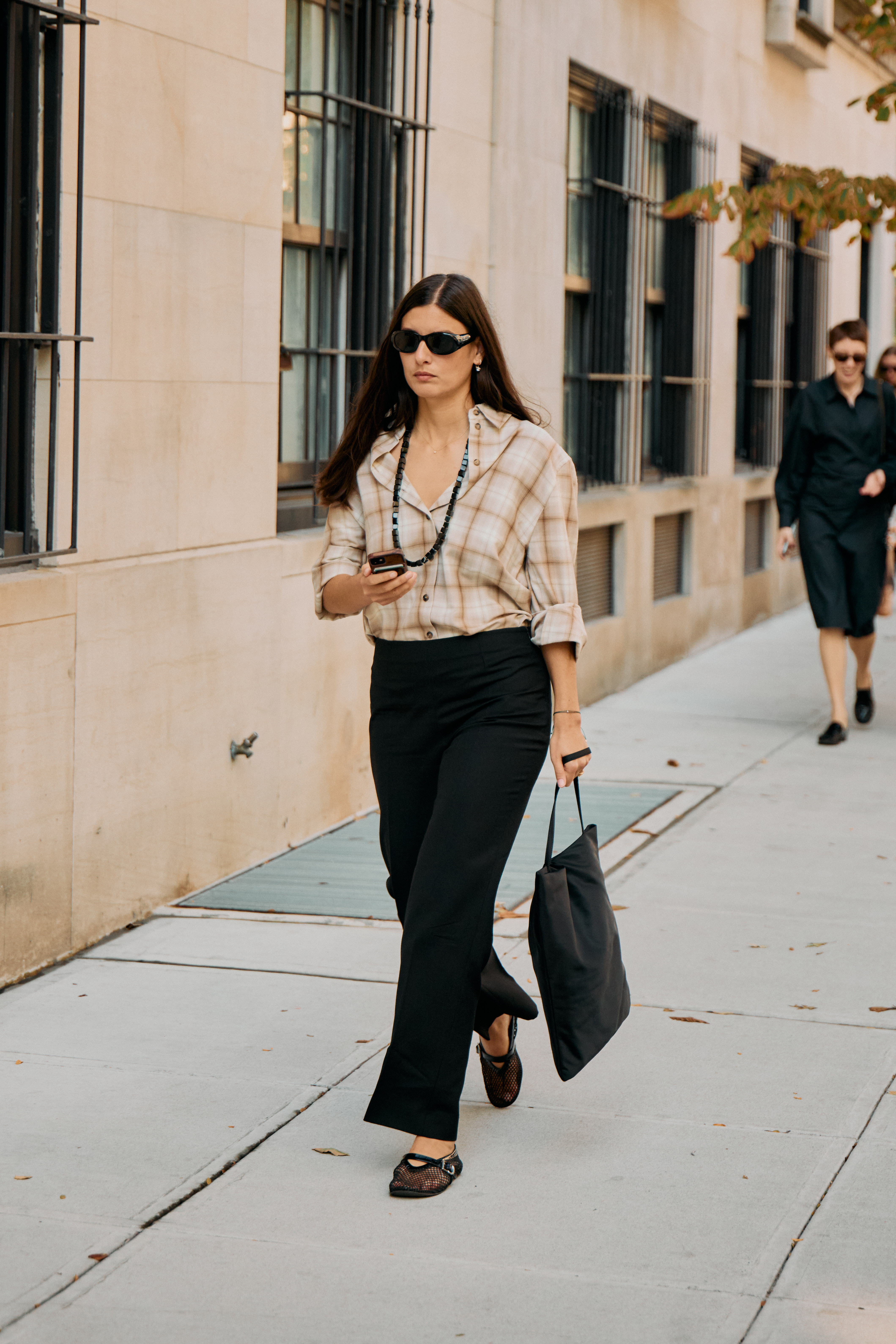 A guest wearing a plaid shirt at the COS F/W 25 show during NYFW.