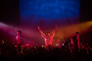 The Sex Pistols (played by Toby Wallace, Anson Boon, Louis Partridge and Jacob Slater) perform a gig to a crowd of riled-up fans