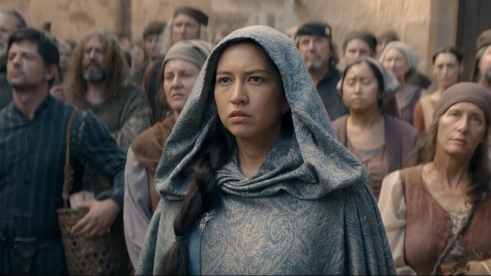 A hooded Mysaria looking annoyed as she stands in a crowd of people in House of the Dragon season 3 episode 8