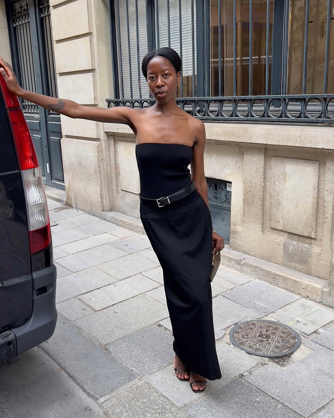 woman wearing black strapless maxi dress with leather belt