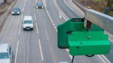 An automated number-plate recognition (ANPR) camera watches over a dual carriageway
