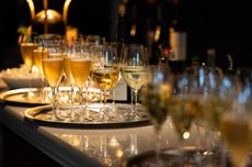Glasses of Champagne and white wine on tray on table
