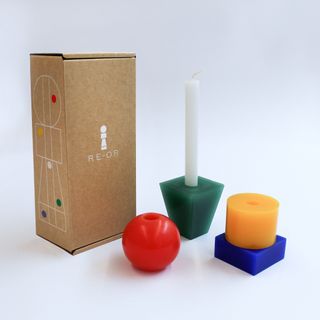 Deconstructed first edition RE-OR interchangeable candle in Notorious RGB, shown with its cardboard packaging.