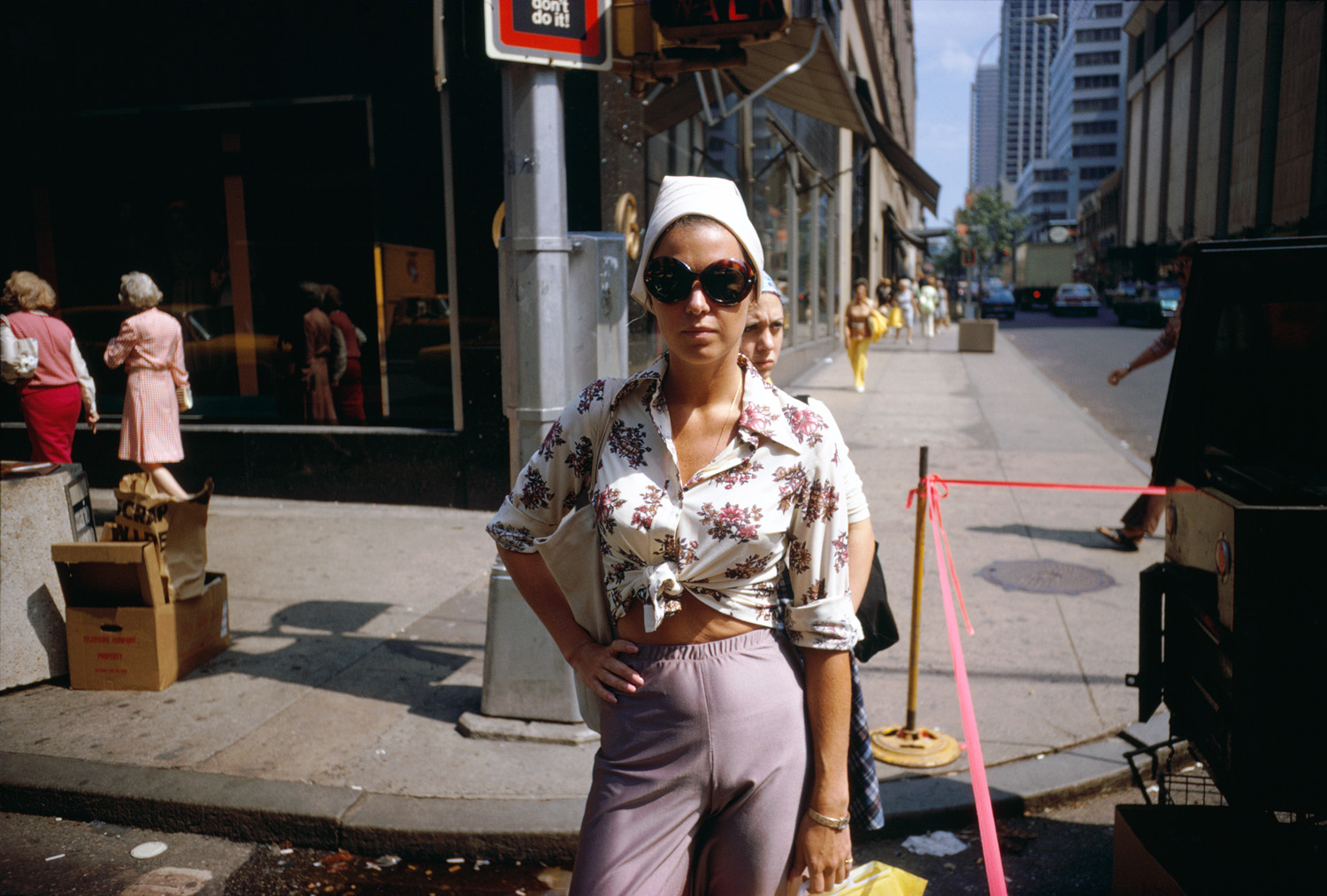 an individual posing on a new york street wearing a flowery short sunglasses and a hat