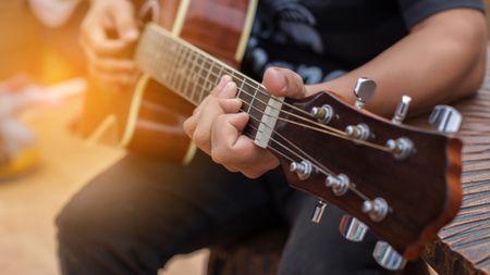 Close-up of man playing acoustic guitar