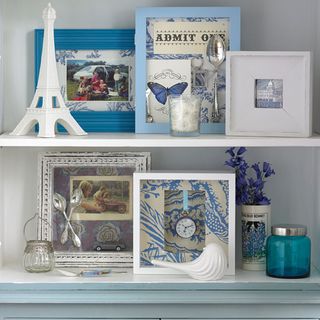 white open frames with an assortment of blue and white picture frames and ornaments