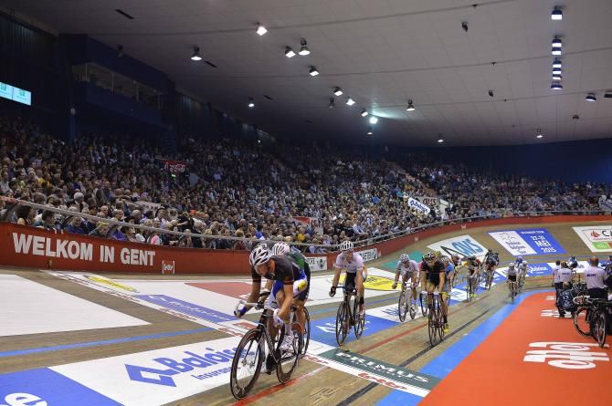 The riders pass over the start/finish line
