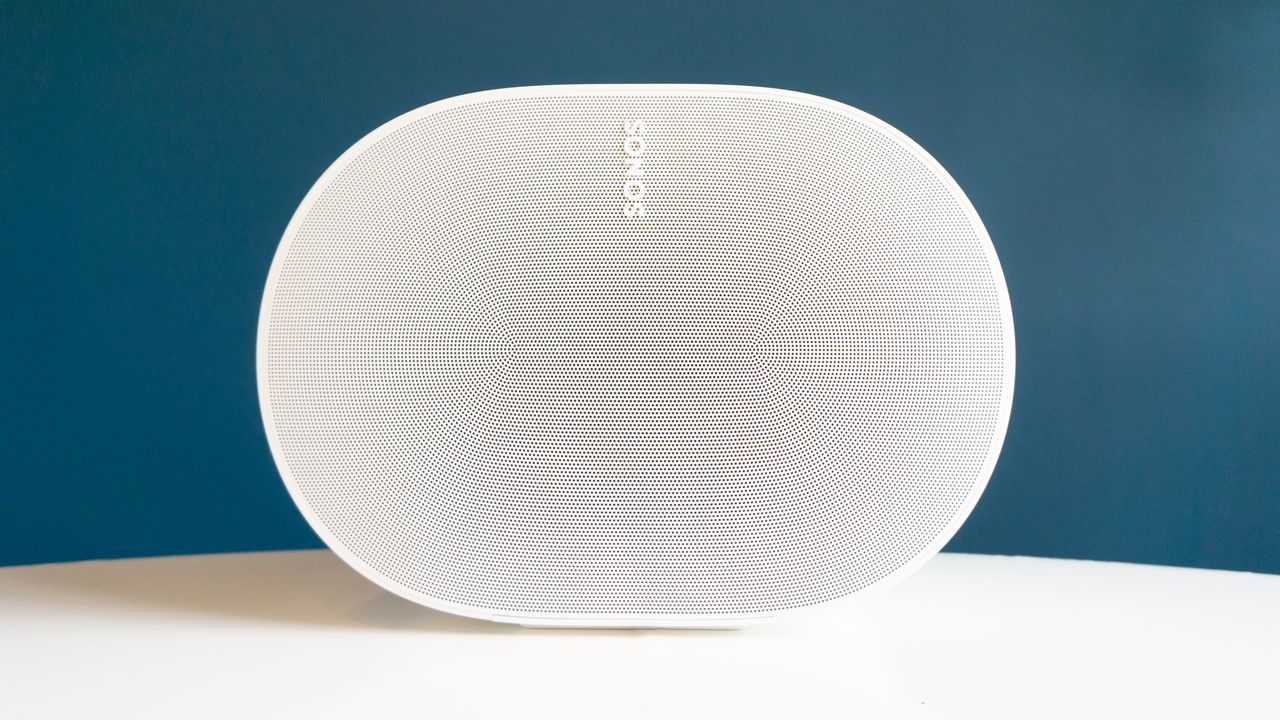 The Sonos Era 300 on white table viewed from directly on. It's an oval from this angle, and we can see the dot pattern of its speaker grille.