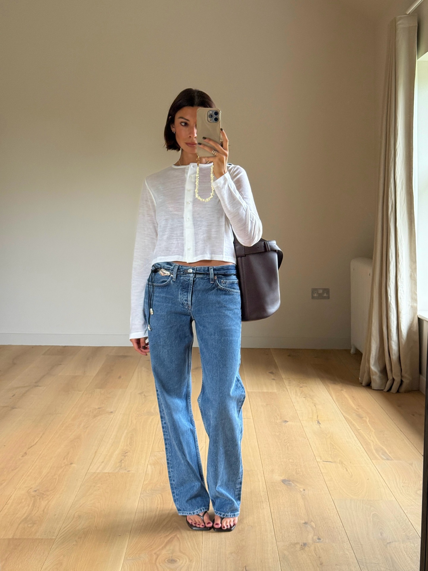 Woman in jeans, white top, and thong sandals