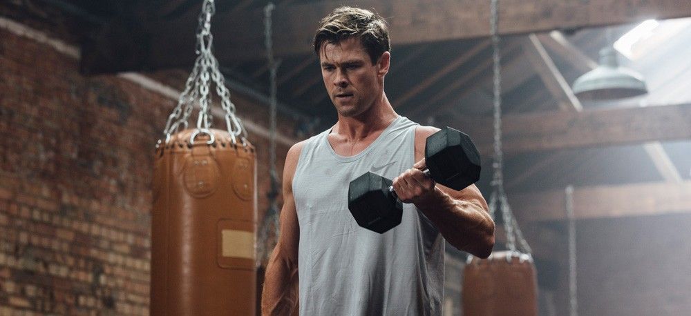 Chris Hemsworth performing dumbbell curl in gym